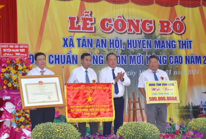 Ông Nguyễn Văn Liệt, Phó Chủ tịch UBND tỉnh Vĩnh Long trao bằng công nhận xã Tân An Hội đạt chuẩn nông thôn mới nâng cao, cờ thi đua cấp tỉnh và công trình phúc lợi trị giá 500 triệu cho Đảng bộ, chính quyền và nhân dân địa phương. Ảnh: Minh Đảm.