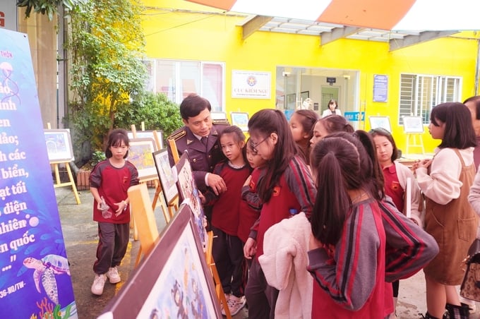 Các em học sinh hào hứng xem triển lãm tranh trong khuôn khổ Lễ Tổng kết và trao giải Cuộc thi vẽ tranh 'Em vẽ đại dương xanh - Ngôi nhà của các loài sinh vật biển'. Ảnh: Hồng Thắm.