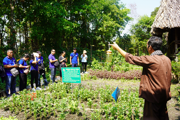 Khách nghe chia sẻ về việc làm nông nghiệp hữu cơ, nông nghiệp tuần hoàn tại nông trại. Ảnh: Nguyễn Thủy.