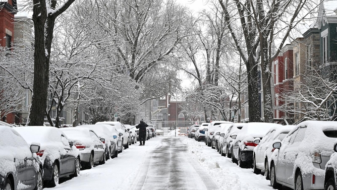 Một người đàn ông dọn tuyết khỏi ô tô của mình ở thủ đô Washington, Mỹ, hôm 19/1. Ảnh: AFP.