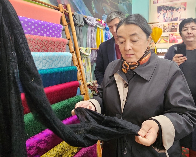 Bà H.E. Mrs. Zulaykho Makhkamova, Chủ tịch Ủy ban Gia đình và Phụ nữ Cộng hòa Uzbekistan xem sản phẩm lụa Nha Xá. Ảnh: Phương Linh.