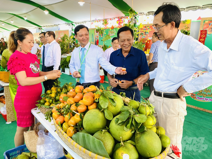 Các đại biểu tham quan và thưởng thức các mặt hàng nông sản đặc sản của huyện Lai Vung được trưng bày tại Ngày Hội. Ảnh: Hoàng Vũ.