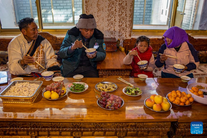 Dân làng ăn tối tại quán ăn ở làng Beiga, huyện Thân Trát, khu tự trị Tây Tạng phía tây nam Trung Quốc . Các loại trái cây trên bàn đều được mua tại cửa hàng trong làng. Ảnh: Tân Hoa Xã.
