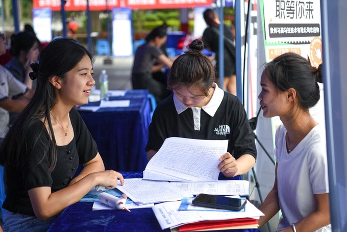 Sinh viên vừa tốt nghiệp đại học đang hỏi về cơ hội việc làm tại Hội chợ việc làm ở quận tự trị Kiềm Đông Nam, tỉnh Quý Châu, Trung Quốc. Ảnh: Tân Hoa Xã