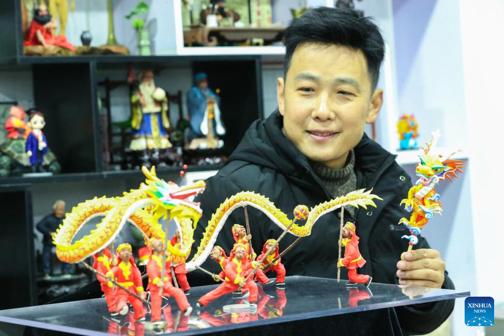 Một nghệ sĩ trưng bày các bức tượng nhỏ bằng bột, một nghệ thuật dân gian truyền thống của Trung Quốc, tại thành phố Trú Mã Điếm, tỉnh Hà Nam, miền trung Trung Quốc. Ảnh: Tân Hoa Xã. 