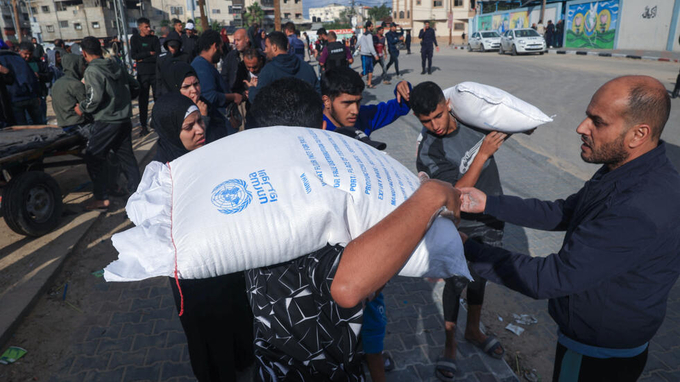 Cơ quan cứu trợ người tị nạn Palestine của Liên hợp quốc (UNRWA) phát bột mì cho người dân Palestine tại trại tị nạn Rafah ở phía nam Dải Gaza hôm 21/11/2023. Ảnh: AFP.