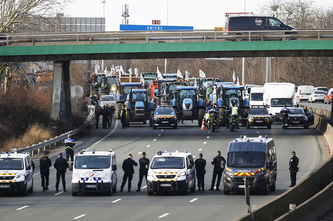 Cảnh sát chặn những người nông dân lái máy kéo biểu tình trên đường cao tốc A15, phía bắc Paris hôm 29/1. Ảnh: Independent.