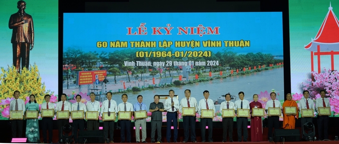 Chủ tịch UBND tỉnh Kiên Giang tặng bằng khen cho các tập thể, cá nhân có thành tích xuất sắc tiêu biểu trong thi đua đặc biệt lập thành tích chào mừng kỷ niệm 60 năm thành lập huyện Vĩnh Thuận. Ảnh: Diễm Trang.