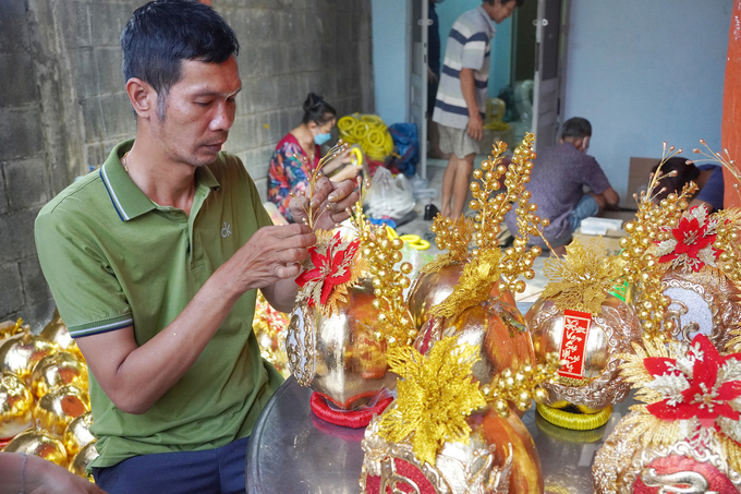 Anh Nguyễn Văn Dình (quê Vĩnh Long) hoàn thiện công đoạn cuối cùng để giao dừa dát vàng cho khách. Ảnh: Nguyễn Thủy.