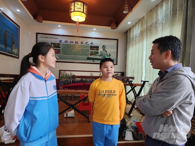 Phóng viên Báo Nông nghiệp Việt Nam (bên phải) trò chuyện cùng hai người cháu của ông Tô Xuân Phát. Ảnh: Vũ Cường.