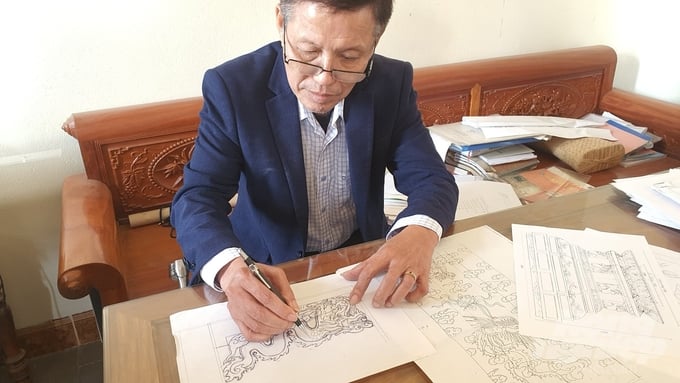 Anh Đỗ Quang Bình phác thảo họa tiết rồng trên giấy trước khi phóng to để làm mẫu đục trên điêu khắc đá.