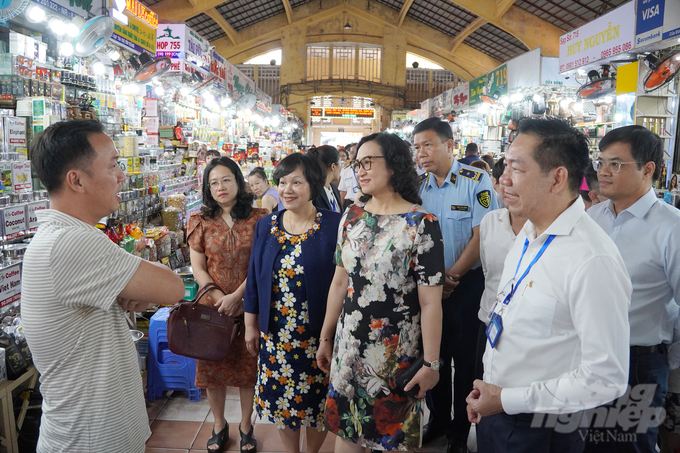 Đoàn khảo sát hỏi thăm tình hình kinh doanh của tiểu thương tại chợ Bến Thành. Ảnh: Nguyễn Thủy.