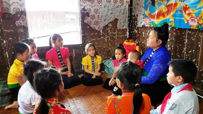 Nghệ nhân ưu tú Điêu Thị Xiêng truyền dạy văn hóa Thái cho các em nhỏ.