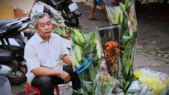 Cảnh tiểu thương ngồi chờ khách là cảnh thường thấy ở chợ hoa, vì không phải hoa nào khách hàng cũng ưa chuộng. Ảnh: Trần Phi.