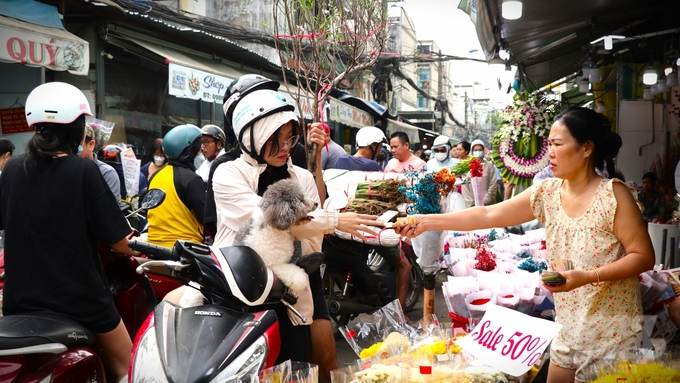 Mua cành đào về chưng Tết, chị Huệ, quận 3 cho biết, năm nay giá hoa dễ mua hơn mọi năm. Hoa cũng đẹp hơn. Huệ đã chọn được 1 cành đào rất ưng ý để trang trí Tết. Ảnh: Trần Phi.