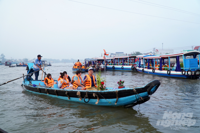 Những du khách Tây cười vui và thư giãn trên thuyền trên dòng sông Hậu, hòa mình vào không gian Tết ấm áp và sôi động của chợ nổi Cái Răng.