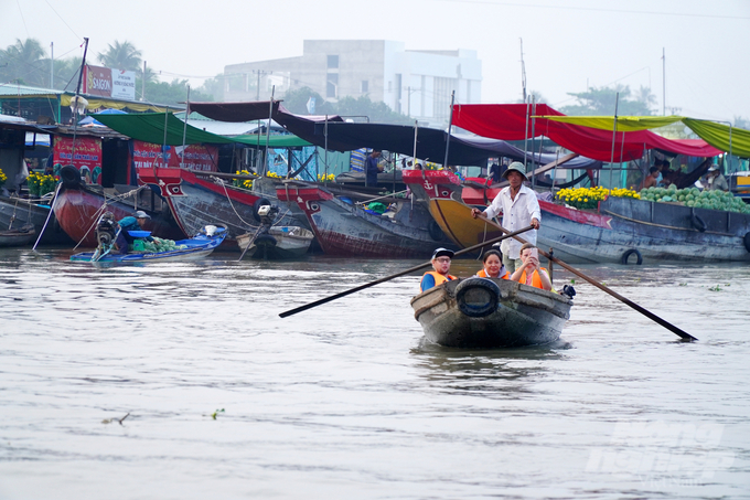 Những du khách Tây cười vui và thư giãn trên thuyền trên dòng sông Hậu, hòa mình vào không gian Tết ấm áp và sôi động của chợ nổi Cái Răng.