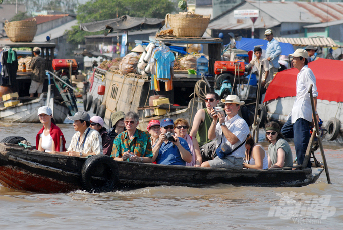 Những du khách Tây cười vui và thư giãn trên thuyền trên dòng sông Hậu, hòa mình vào không gian Tết ấm áp và sôi động của chợ nổi Cái Răng.