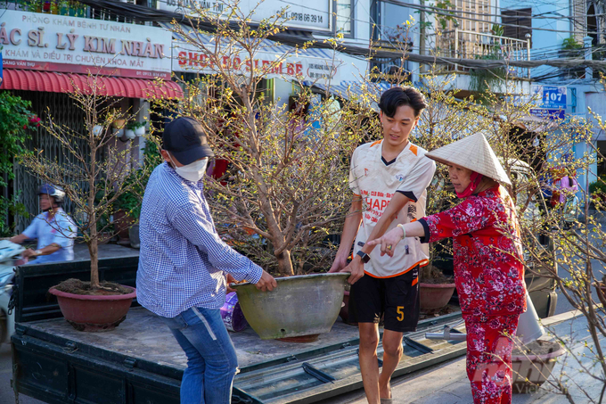 Tiểu thương tất bật dọn dẹp không gian để bày bán hoa kiểng Tết.