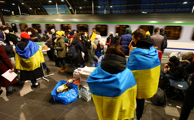 Các tình nguyện viên chờ đón người tị nạn Ukraine tại ga trung tâm Berlin hồi tháng 2/2022. Ảnh: Reuters.