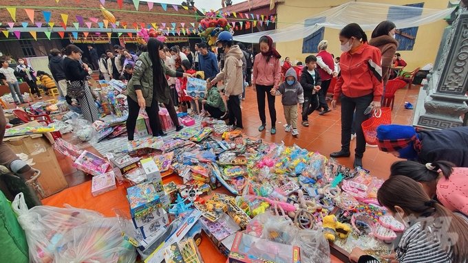 Những món đồ chơi được bày trên tấm bạt trải trên sân đình làng...