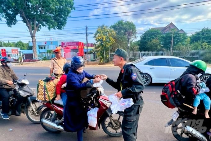 Ngày 14/2 (Mùng 5 Tết Nguyên đán) lực lượng Cảnh sát giao thông số 2 (Phòng Cảnh sát giao thông Công an tỉnh Đồng Nai) phát miễn phí nước suối cho người đi xe máy trên quốc lộ 20. Ảnh: MV.