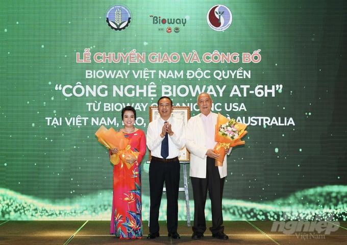Thứ trưởng Bộ NN-PTNT Phùng Đức Tiến tặng hoa chúc mừng sự kiện chuyển giao công nghệ BIOWAY AT-6H từ tập đoàn Bioway USA cho tập đoàn Bioway Việt Nam​. Ảnh: Thanh Liêm.