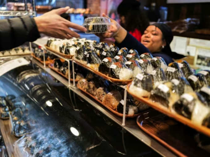 A customer (L) buys a stuffed rice ball, known as 'onigiri', at the Omusubi Gonbei shop in Manhattand. Photo: AFP