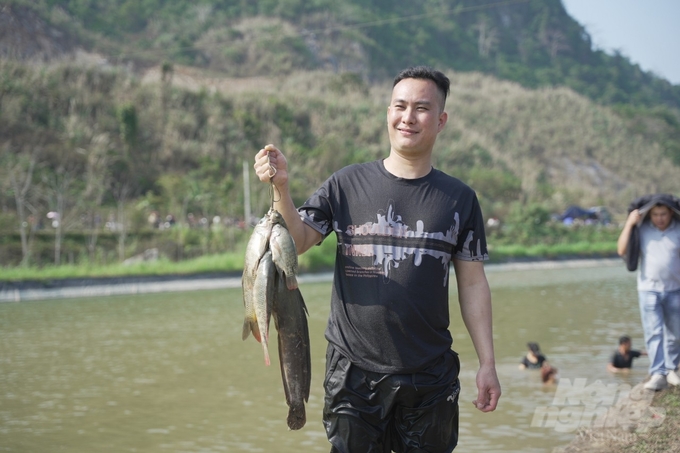 Một du khách hào hứng khoe thành tích của mình khi tham dự hội thi bắt cá bằng tay.