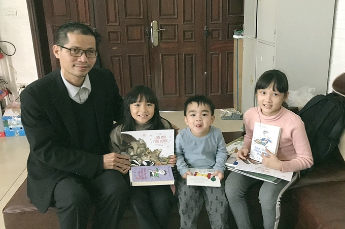 Nguyễn Quang Thạch mừng tuổi sách cho các cháu nhỏ ở xã Thạch Hạ, TP Hà Tĩnh, tỉnh Hà Tĩnh.