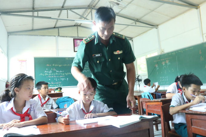 Thầy giáo mặc áo lính Trần Bình Phục gắn bó với 'lớp học tình thương' suốt 15 năm qua. Ảnh: Ngọc Khanh.