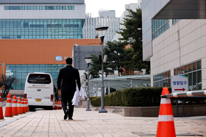 Ryu Hada, 25 tuổi, một trong hàng nghìn bác sĩ thực tập ở Hàn Quốc đình công, cầm chiếc áo blouse trắng rời khỏi bệnh viện nơi anh làm việc ở thủ đô Seoul, Hàn Quốc, hôm 25/2. Ảnh: Reuters.