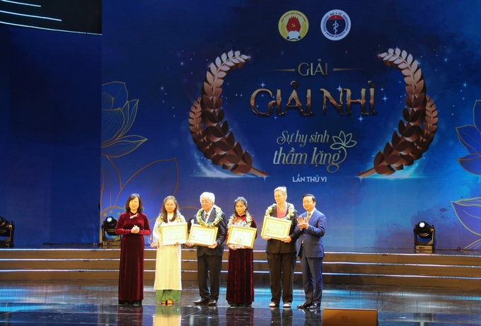 Phó Thủ tướng Chính phủ Trần Hồng Hà (bìa phải) và Bộ trưởng Bộ Y tế Đào Hồng Lan (bìa trái) trao giải Nhì cho các tác giả đoạt giải và nhân vật trong tác phẩm.