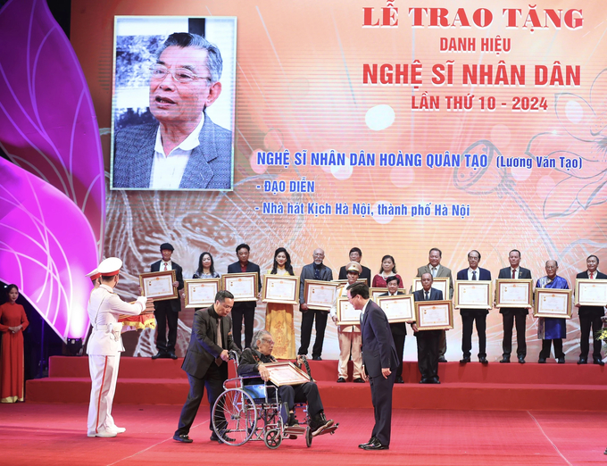 Đạo diễn Hoàng Quân Tạo đón nhận danh hiệu Nghệ sĩ Nhân dân trên chiếc xe lăn.