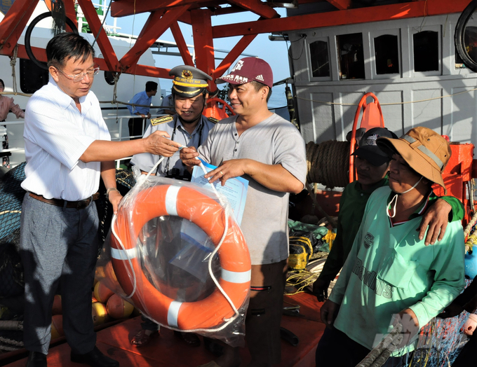 Deputy Director of the Department of Agriculture and Rural Development of Kien Giang Province Quang Trong Thao (left) along with leaders of the Fisheries Association and fisheries surveillance force boarded the ship to visit, encourage, give life buoys, and give letters calling on fishermen to combat IUU exploitation, on the occasion of the sea departure at the beginning of the year. Photo: Trung Chanh.