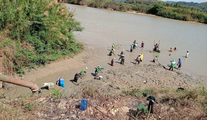 Người dân dọc sông Krông Nô nạo vét mương để lấy nước phục vụ sản xuất. Ảnh: Quang Yên.