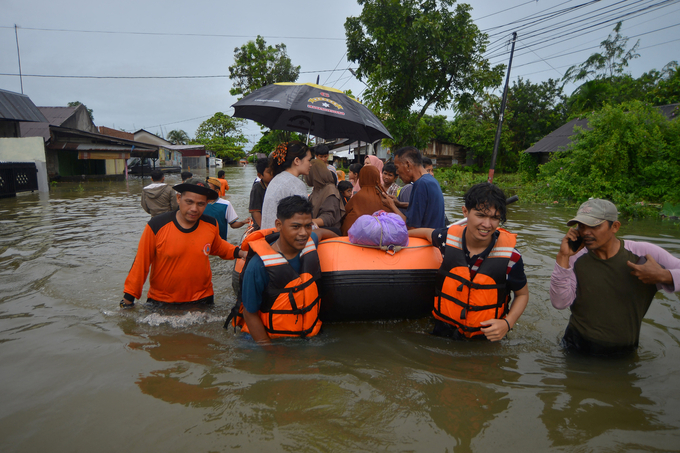 Cán bộ thuộc Cơ quan Quản lý Thảm họa Địa phương (BPBD) sử dụng thuyền bơm hơi để sơ tán người dân khỏi khu vực bị ảnh hưởng bởi lũ lụt ở Padang, tỉnh Tây Sumatra, Indonesia. Ảnh: Reuters.