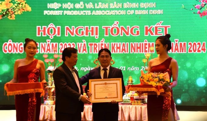 Mr. Nguyen Tuan Thanh, Standing Vice Chairman of Binh Dinh Provincial People's Committee, on behalf of the Ministry of Agriculture and Rural Development, presented the Certificate of Merit from the Minister of Agriculture and Rural Development to the Forest Products Association of Binh Dinh. Photo: V.D.T.