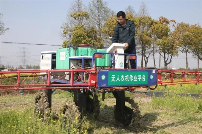 He Yangyang đang thử nghiệm một chiếc máy nông nghiệp trên cánh đồng ở quê hương thuộc quận Tùng Giang, ngoại ô thành phố Thượng Hải. Ảnh: Shanghai Daily.