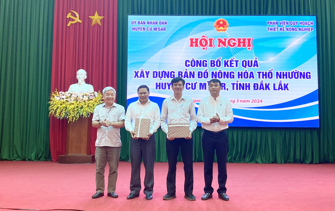 Lãnh đạo UBND huyện Cư M'gar nhận tài liệu nghiên cứu từ các chuyên gia. Ảnh: Quang Yên.