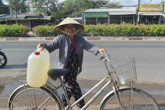 Bà Trần Thị Thu Trang dắt xe đạp đi lấy nước ngọt. Ảnh: Minh Đảm.