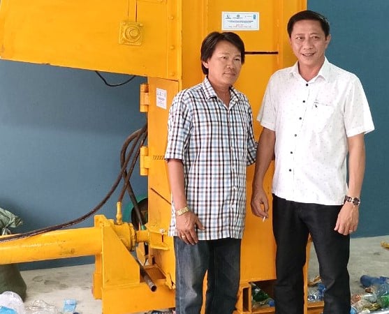 Mr. Dao Xuan Thien, Director of the Management Board of Binh Dinh fishing port (right), in front of a trash compactor installed at Quy Nhon fishing port. Photo: V.D.T.