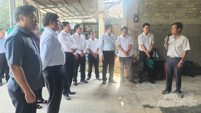 Chairman Tran Van Chung (far right) introduces the 3-in-1 rice dryer he built himself. Photo: HT.