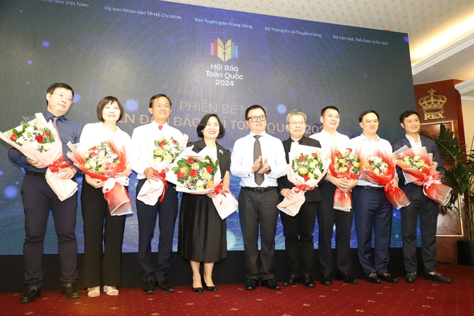 Chủ tịch Hội Nhà báo Việt Nam Lê Quốc Minh tặng hoa cho 10 nhà báo chủ trì 10 phiên thảo luận. Ảnh: N.Tùng.