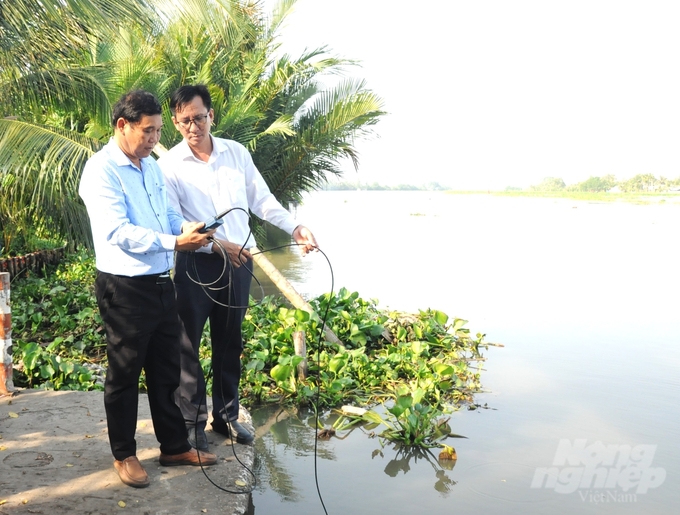 Ông Ngô Minh Long (bên phải), Giám đốc Sở NN-PTNT tỉnh Hậu Giang trực tiếp cùng cán bộ Chi cục Thủy lợi tỉnh Hậu Giang đo kiểm tra độ mặn trên sông Cái Lớn thuộc địa bàn thành phố Vị Thanh, ghi nhận độ mặn đang tăng cao trong những ngày gần đây. Ảnh: Trung Chánh.