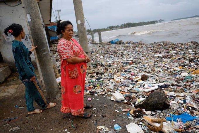Người dân nhìn rác thải dạt vào bờ biển tại làng chài Teluk, thuộc huyện Pandeglang, tỉnh Banten, Indonesia, hôm 15/3. Ảnh: Reuters.