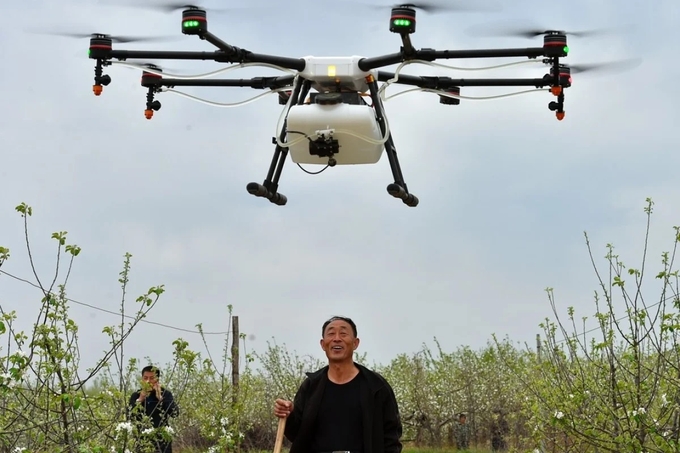 Nông dân điều khiển máy bay không người lái phun thuốc trừ sâu trên một cánh đồng thuộc tỉnh Sơn Tây, Trung Quốc. Ảnh: Xinhua.