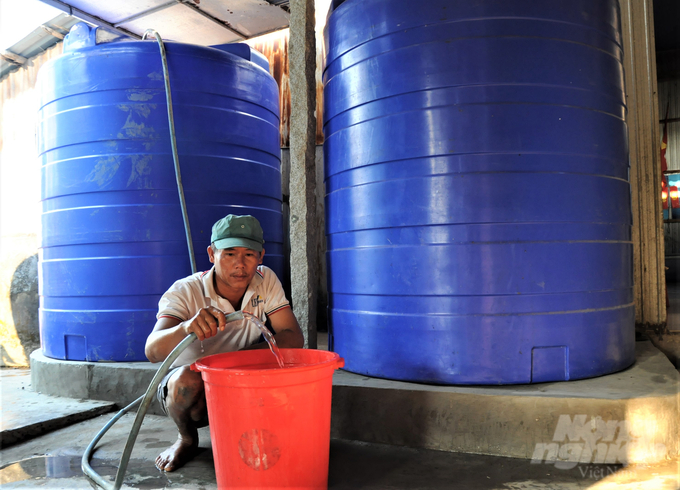 Ngoài tích trữ nước vào hệ thống lu có sẵn, hộ ông Chi còn đầu tư mua 2 bồn nhựa loại 5.000 lít/bồn để dự trữ, phòng khi nguồn nước ngầm suy giảm, trạm cấp nước không thể hoạt động. Ảnh: Trung Chánh.