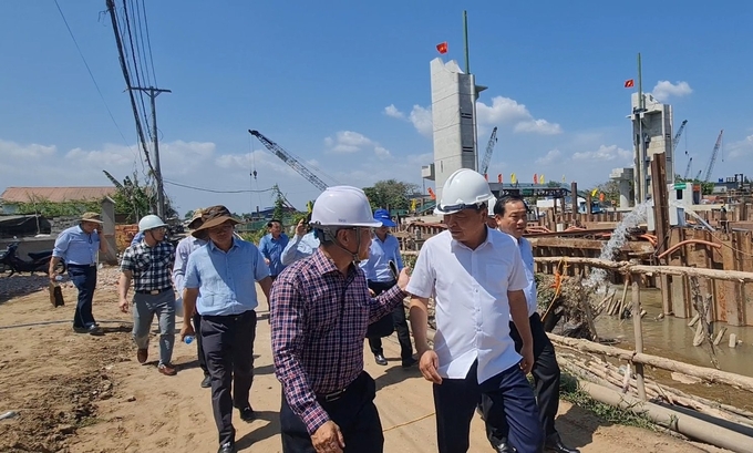 Thứ trưởng Bộ NN-PTNT Nguyễn Hoàng Hiệp (áo trắng) kiểm tra tiến độ thi công cống Nguyễn Tấn Thành vào tháng 3/2024. Ảnh: Minh Đảm.