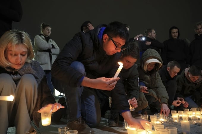 Người dân thắp nến tưởng niệm những nạn nhân vụ khủng bố tại trung tâm thương mại Crocus City Hall ở ngoại ô Moscow, Nga, tối 22/3. Ảnh: AP.